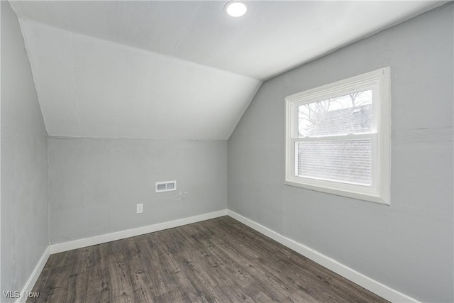 bonus room with visible vents, dark wood-style flooring, baseboards, and vaulted ceiling