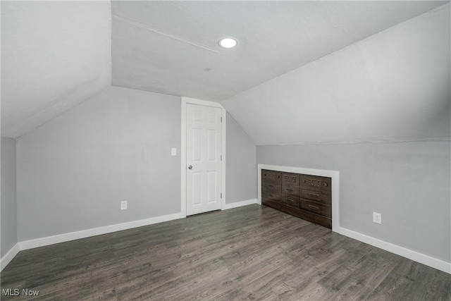 additional living space featuring vaulted ceiling, baseboards, and wood finished floors