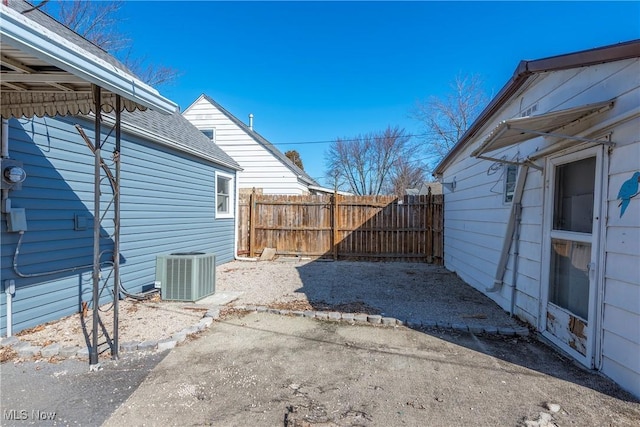 view of yard with central AC unit and fence