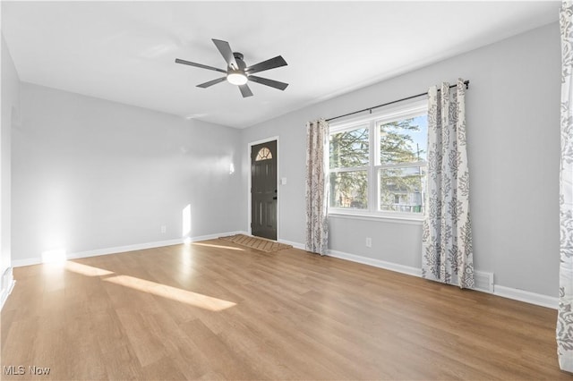 unfurnished living room featuring baseboards, wood finished floors, and a ceiling fan