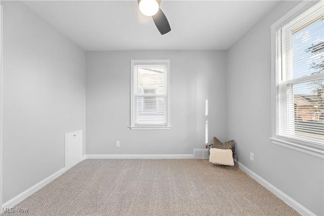 unfurnished room with carpet, a ceiling fan, baseboards, and a healthy amount of sunlight