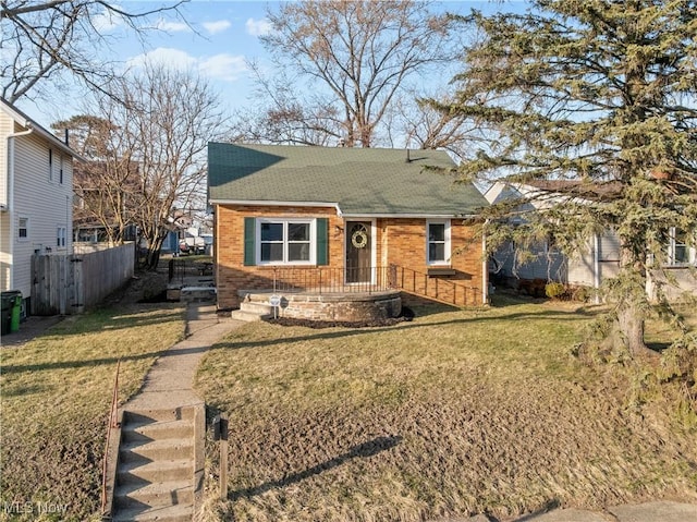 bungalow-style home with a front lawn, fence, and roof with shingles