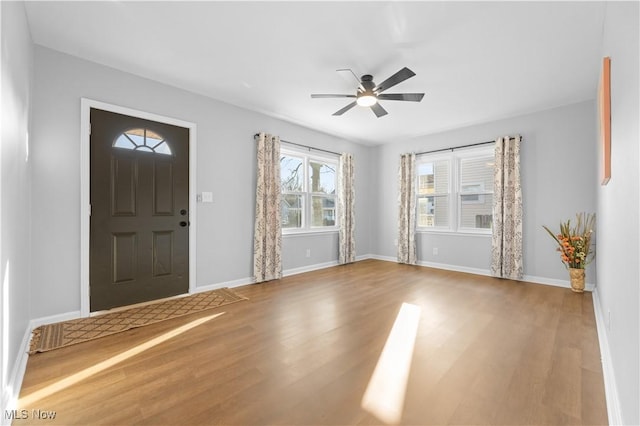 foyer entrance featuring wood finished floors, baseboards, and ceiling fan