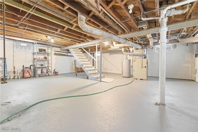 unfinished basement with gas water heater, stairway, and heating unit