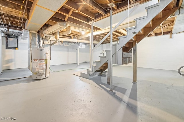 unfinished basement with stairs, electric panel, and water heater