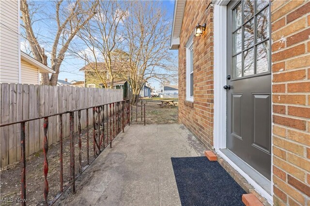 exterior space featuring brick siding and fence