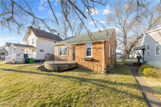 rear view of house with brick siding, a wooden deck, and a yard