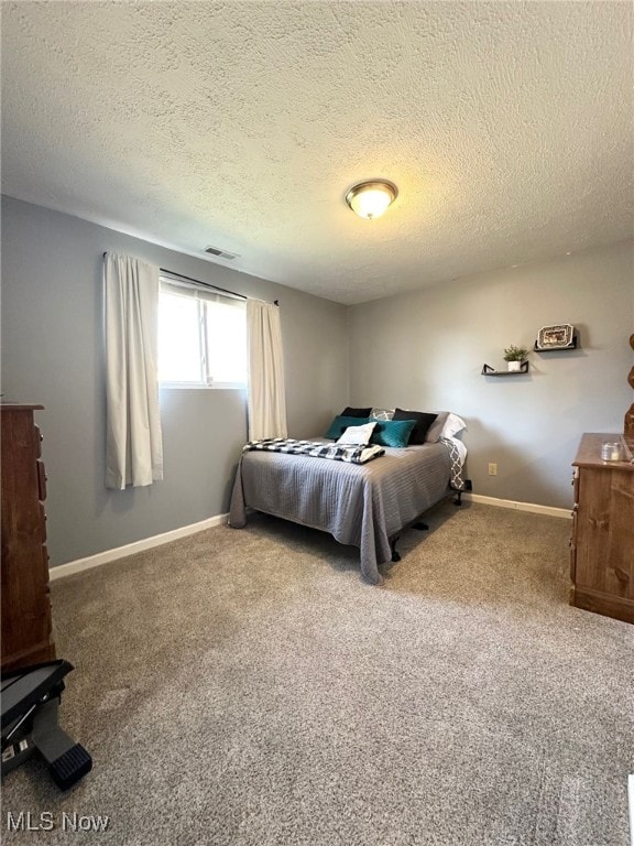 bedroom with visible vents, baseboards, a textured ceiling, and carpet flooring