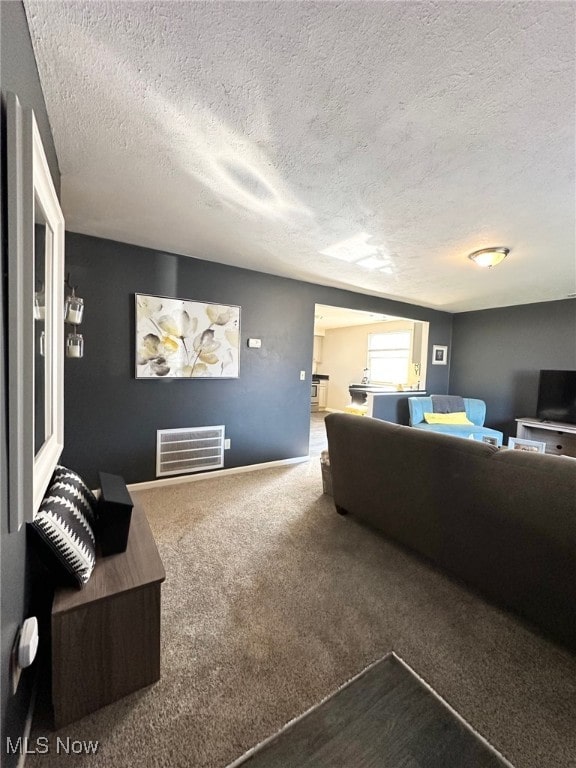 carpeted living room with visible vents and a textured ceiling