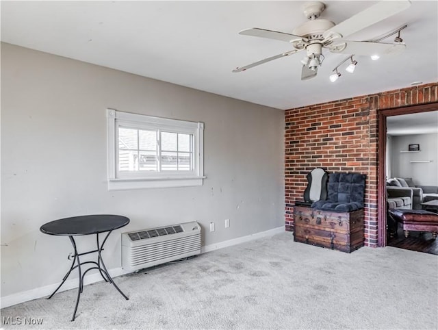 sitting room with baseboards, ceiling fan, carpet flooring, and a wall unit AC