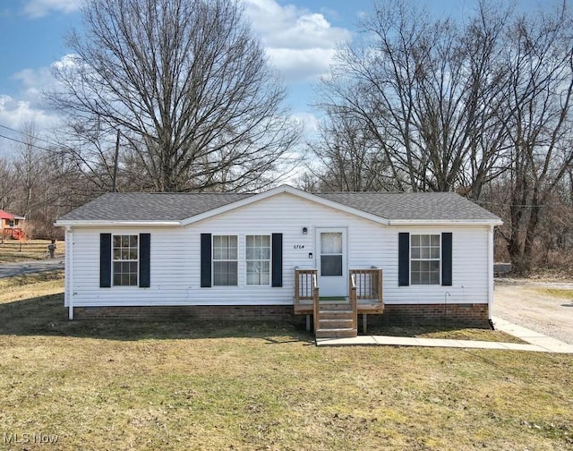 view of front of property with crawl space, roof with shingles, and a front yard