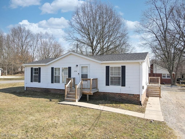 manufactured / mobile home with a front yard and a shingled roof