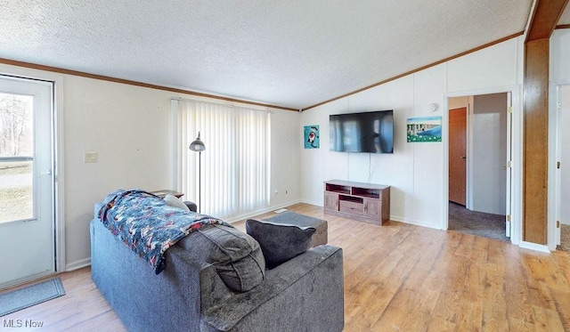 living area with lofted ceiling, a textured ceiling, light wood-style flooring, and crown molding