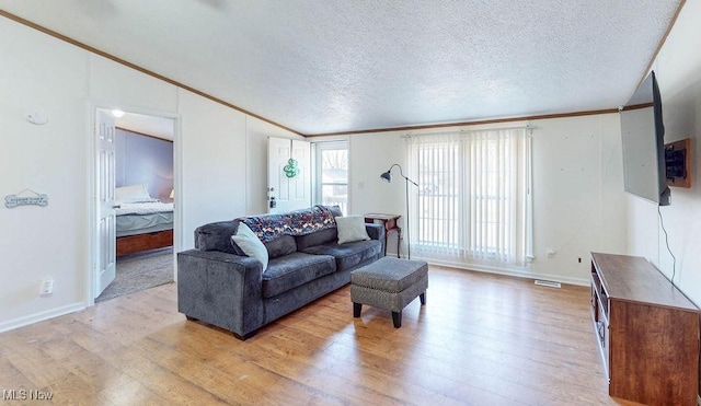 living area featuring lofted ceiling, light wood-style flooring, and crown molding