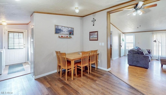 dining room featuring a textured ceiling, wood finished floors, and ornamental molding