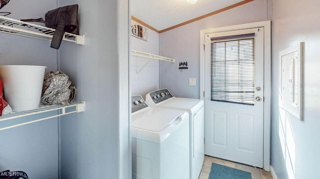 laundry area with a textured ceiling, separate washer and dryer, laundry area, and crown molding