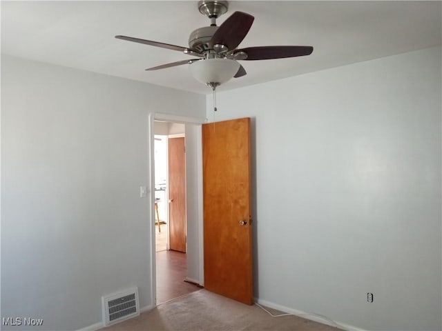 empty room with visible vents, baseboards, ceiling fan, and carpet flooring