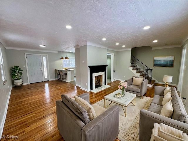 living area featuring baseboards, stairs, recessed lighting, wood finished floors, and a textured ceiling