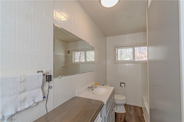 bathroom with plenty of natural light, toilet, and tile walls