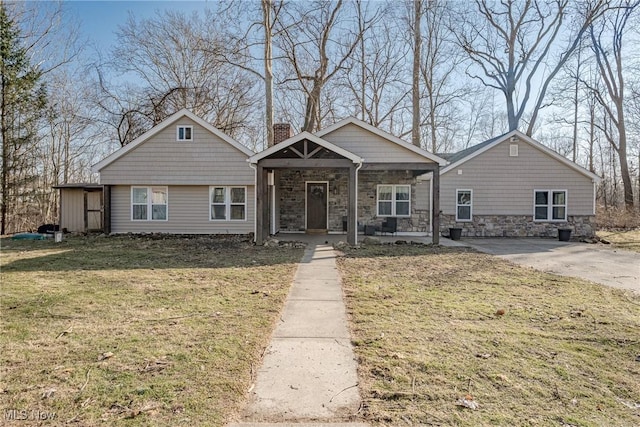 view of front of property with stone siding, covered porch, a chimney, and a front lawn