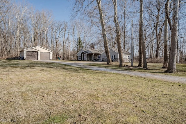 view of yard with an outbuilding, driveway, and a garage