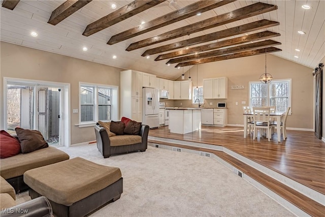 living area featuring light wood finished floors, recessed lighting, lofted ceiling with beams, and baseboards