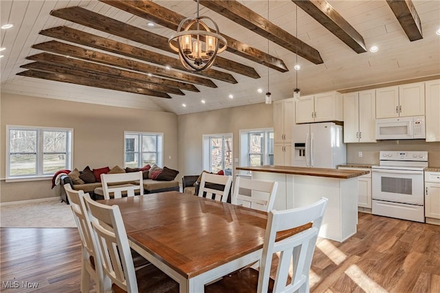 dining room with vaulted ceiling with beams, wood ceiling, and light wood-type flooring