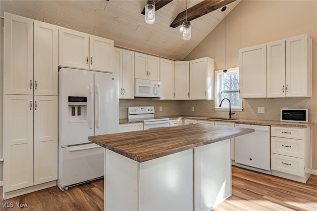 kitchen featuring vaulted ceiling with beams, butcher block counters, white appliances, white cabinetry, and a sink