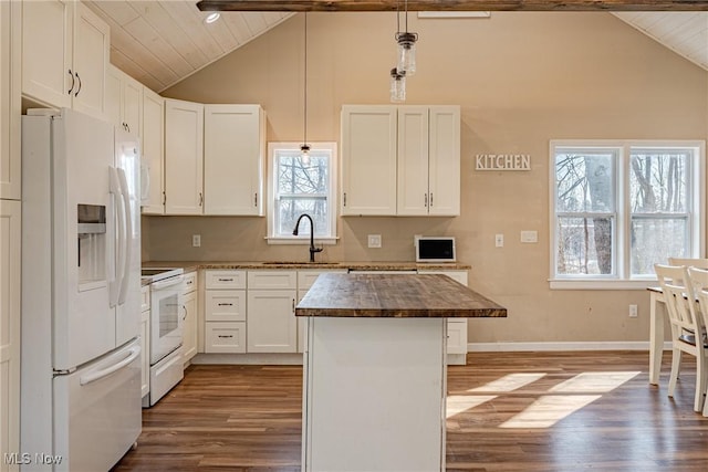 kitchen featuring a sink, a center island, white appliances, vaulted ceiling with beams, and dark wood-style flooring