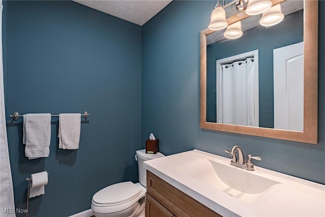 bathroom featuring a textured ceiling, toilet, vanity, and baseboards