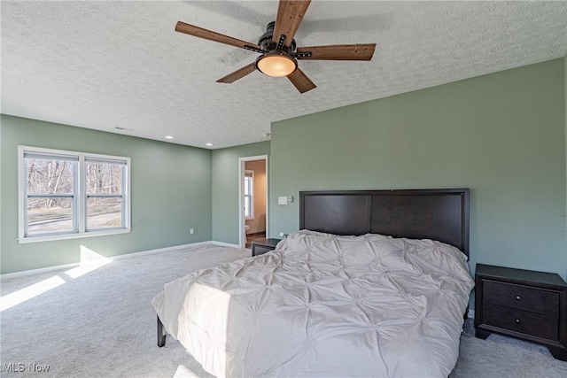 bedroom with ceiling fan, a textured ceiling, baseboards, and carpet floors