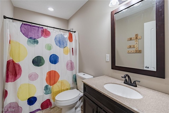 bathroom featuring toilet, vanity, and a shower with curtain