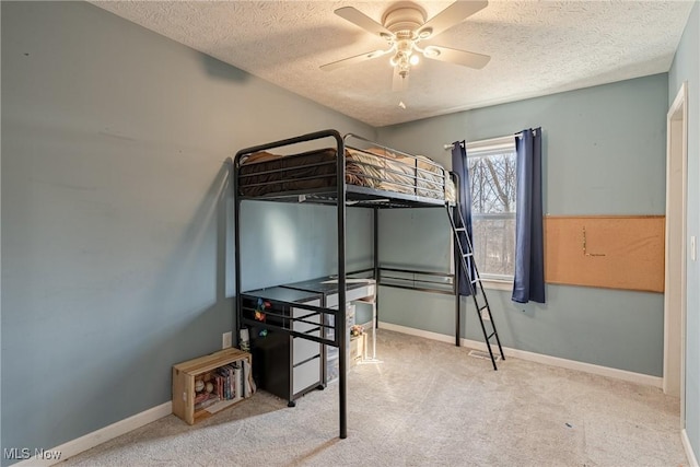 carpeted bedroom featuring ceiling fan, a textured ceiling, and baseboards