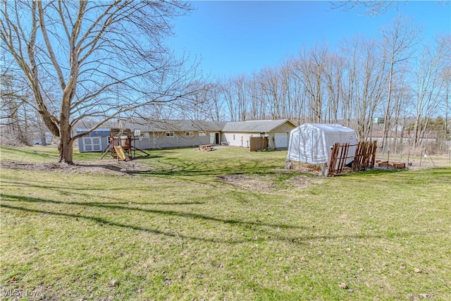 view of yard featuring an outdoor structure, a playground, and a shed