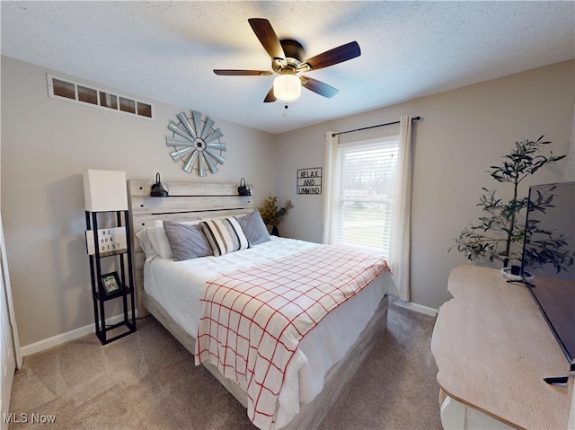 bedroom featuring visible vents, light colored carpet, and a textured ceiling