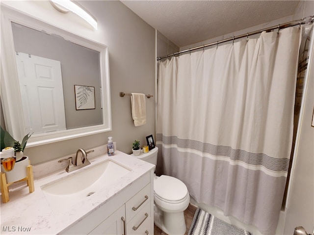 bathroom featuring toilet, a textured ceiling, vanity, and a shower with shower curtain