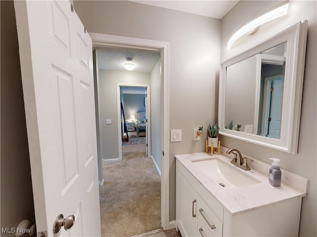 bathroom featuring baseboards, a textured ceiling, and vanity