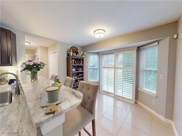 dining area featuring light tile patterned floors and baseboards