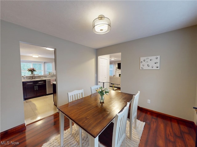 dining space with baseboards and light wood-type flooring