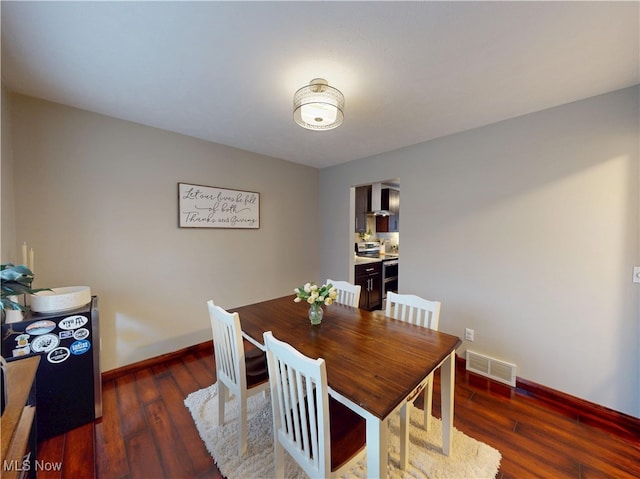 dining room featuring visible vents, baseboards, and wood finished floors