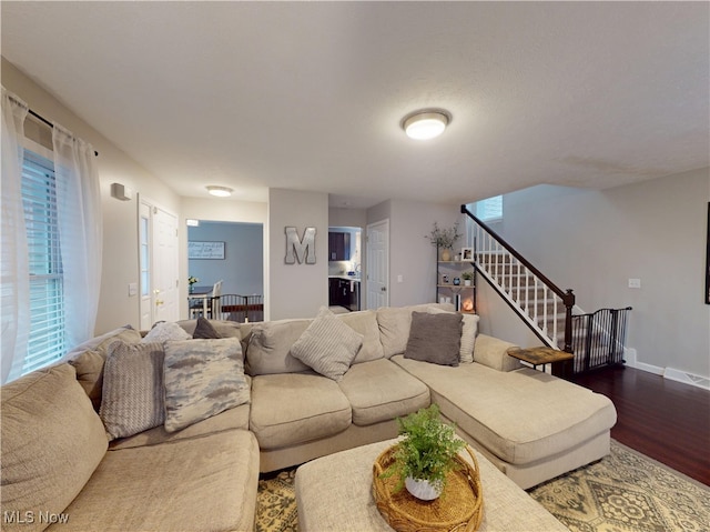 living room featuring stairs, dark wood-style floors, and baseboards