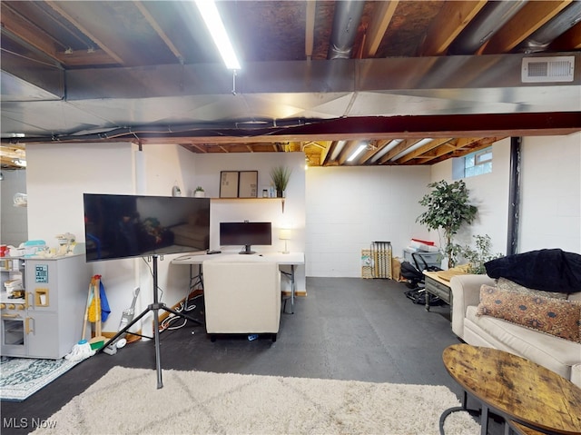 unfinished basement featuring visible vents and concrete block wall