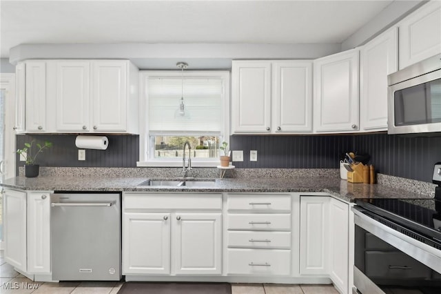 kitchen featuring a sink, stainless steel appliances, stone countertops, and white cabinets