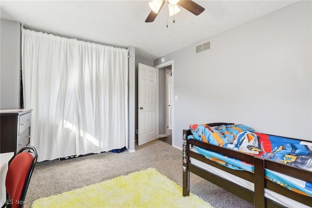 carpeted bedroom with visible vents, baseboards, and ceiling fan