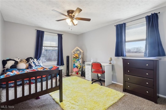 carpeted bedroom with baseboards, a textured ceiling, and ceiling fan