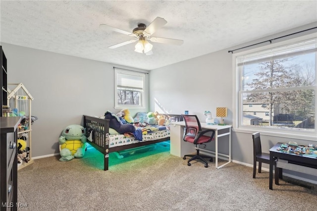 carpeted bedroom featuring ceiling fan, a textured ceiling, and baseboards