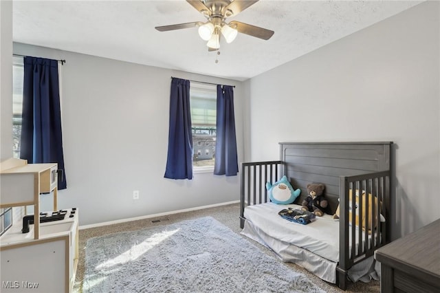 carpeted bedroom featuring visible vents, baseboards, and a ceiling fan