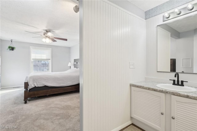 bathroom featuring a textured ceiling, vanity, and a ceiling fan