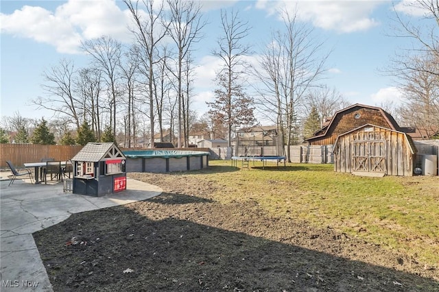 view of yard with a fenced in pool, a fenced backyard, a patio, and an outdoor structure