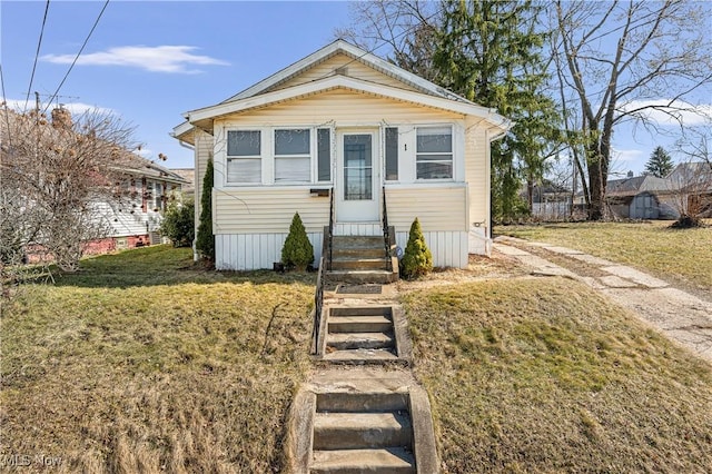 view of front of home with entry steps and a front lawn